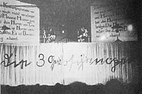 The original production, showing the half-curtain and projected slides